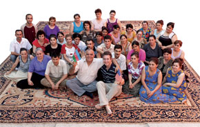 Richard and weavers in Azerbaijan sitting on a custom-made 20 x 22 ft Serapi carpet
