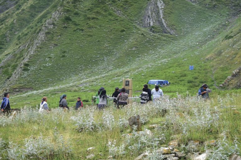 Pilgrims visit a gravesite at the foot of Mount Babadag