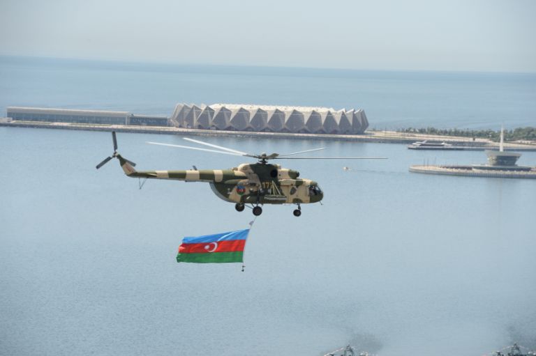 A military helicopter flies the flag above Baku Bay. Photo: Azertaj
